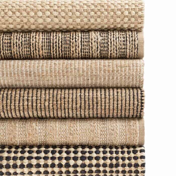 Stack of Sisal and Jute Rugs shows various patterns and colors | 9 best sisal and jute area rugs