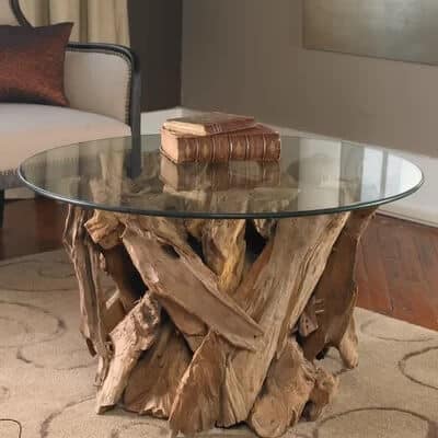 Driftwood Coffee Table with Glass Top. Bring striking style to any space. Eye-catching coffee table is naturally shaped teak wood base and glass top. Top it with the rope-wrapped decor and a teal accent for a touch of beach-chic style. #beachcottage #furniture #driftwood